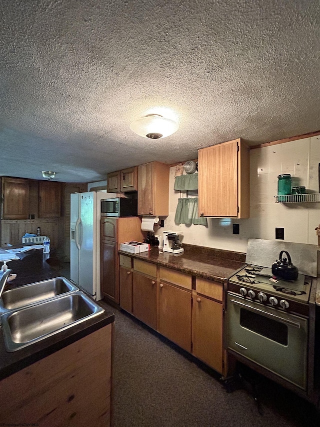 kitchen featuring range, sink, a textured ceiling, and white fridge with ice dispenser