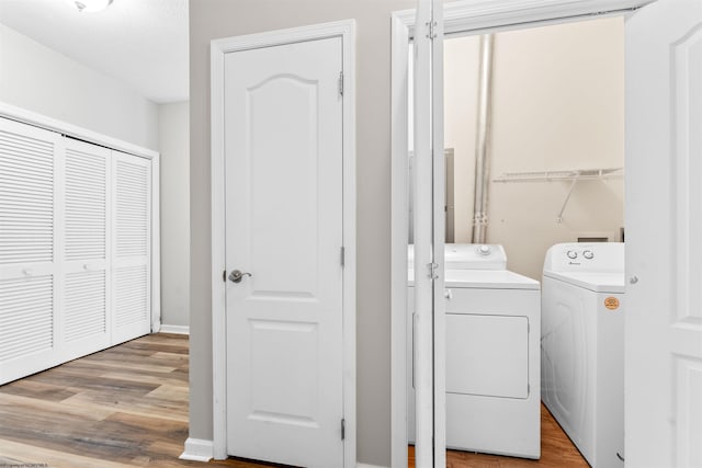 laundry room featuring washing machine and dryer and light wood-type flooring