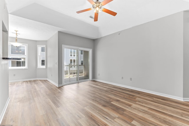 spare room with ceiling fan, wood-type flooring, and vaulted ceiling