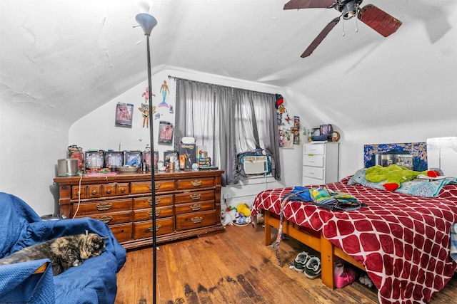 bedroom with ceiling fan, vaulted ceiling, and wood-type flooring