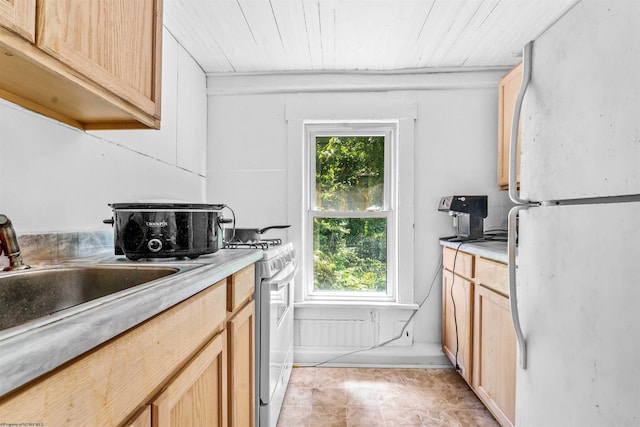 kitchen featuring white appliances and light brown cabinetry