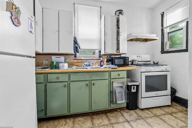 kitchen featuring sink, green cabinetry, and white appliances