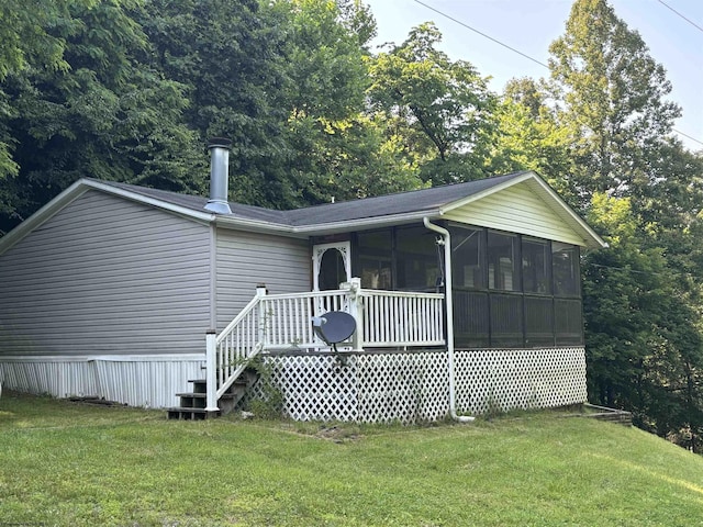 exterior space featuring a sunroom and a lawn