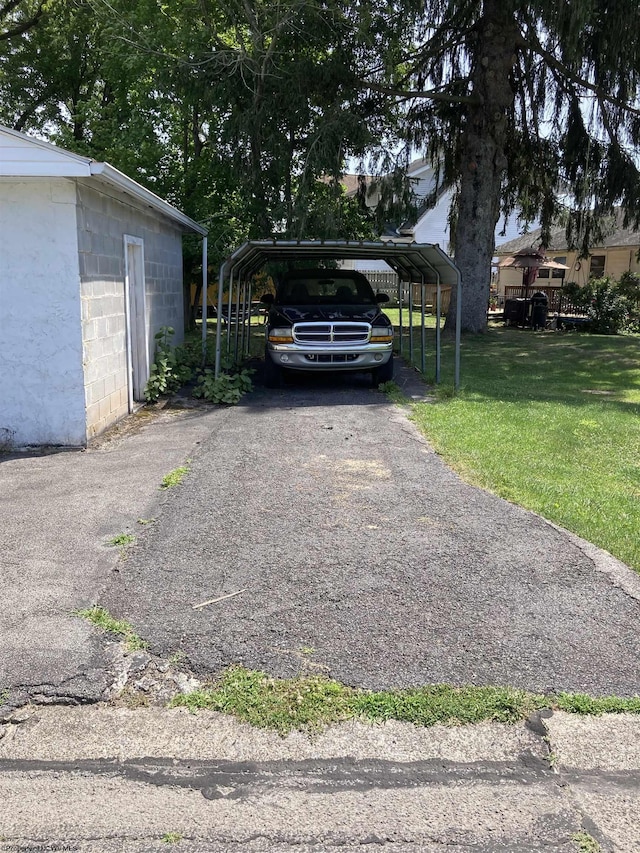 view of vehicle parking with a lawn and a carport