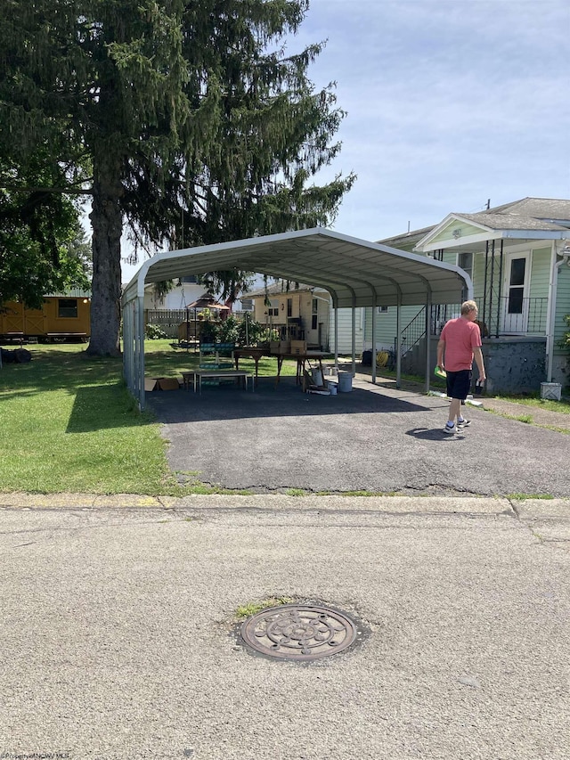 view of vehicle parking with a carport and a yard