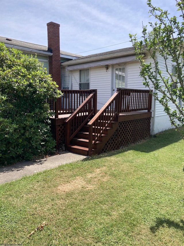 rear view of house with a wooden deck and a yard