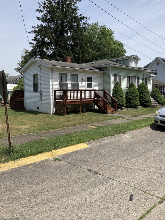 view of front facade featuring a wooden deck and a front yard