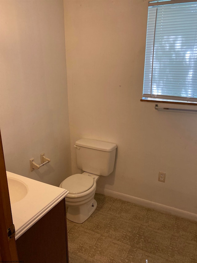 bathroom featuring tile flooring, vanity, and toilet