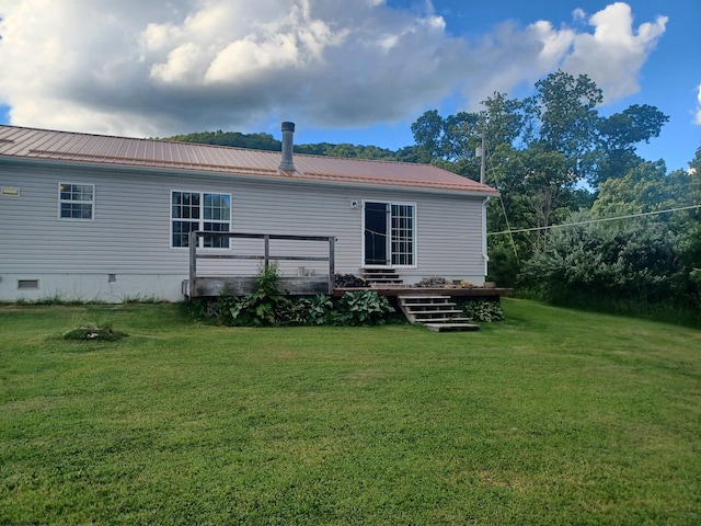 rear view of property with a deck and a lawn