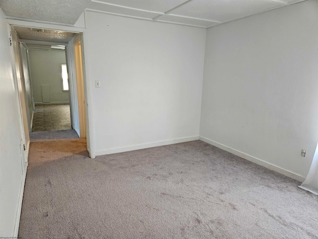 empty room with carpet floors and a textured ceiling