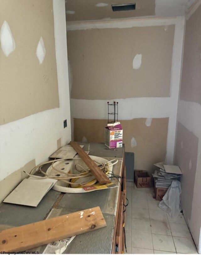 interior space featuring light tile patterned flooring and ornamental molding