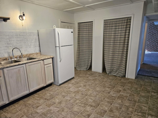 kitchen with decorative backsplash, sink, white refrigerator, and tile patterned flooring