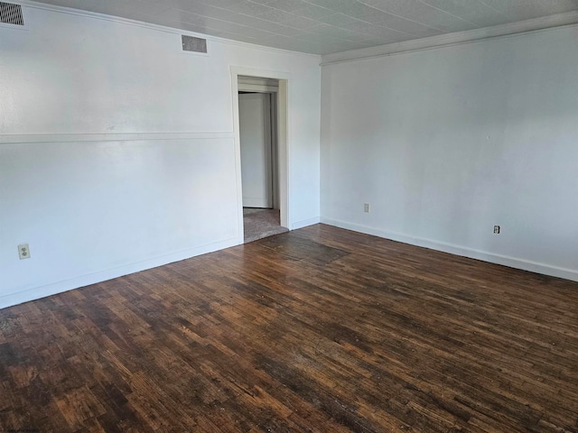 empty room with dark wood-type flooring and crown molding