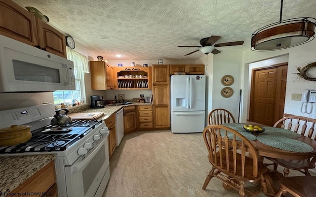 kitchen featuring ceiling fan, white appliances, sink, and a textured ceiling