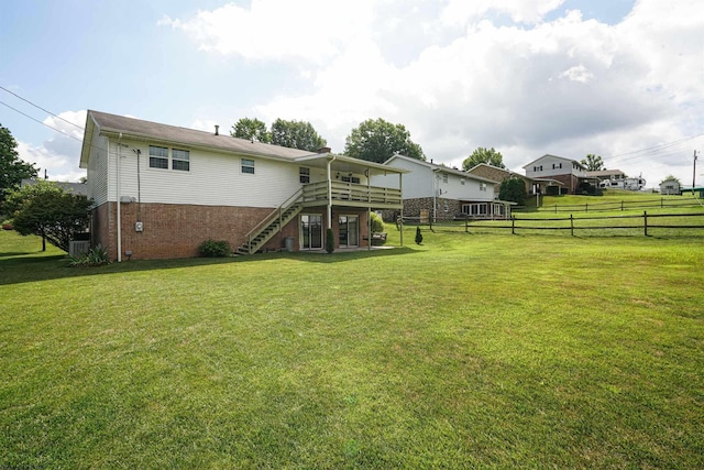 back of house with a wooden deck and a yard