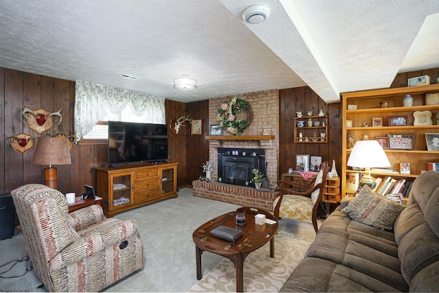 carpeted living room with a fireplace, a textured ceiling, and wood walls