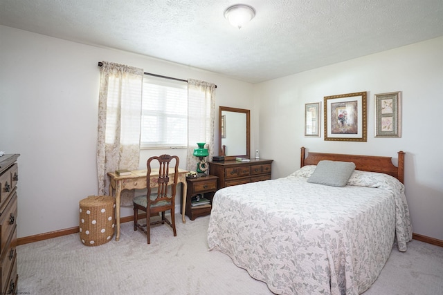 bedroom featuring light carpet and a textured ceiling