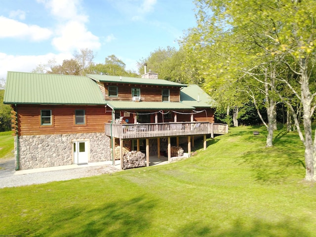 back of property featuring a lawn and a wooden deck