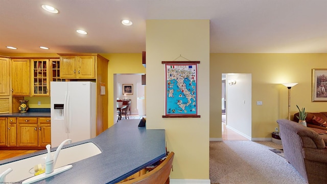 kitchen featuring light colored carpet and white fridge with ice dispenser