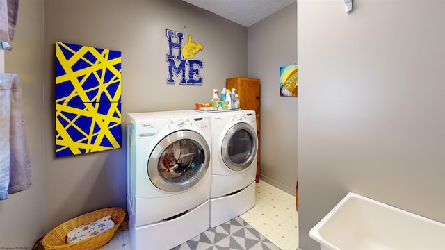 washroom with a textured ceiling and washing machine and clothes dryer