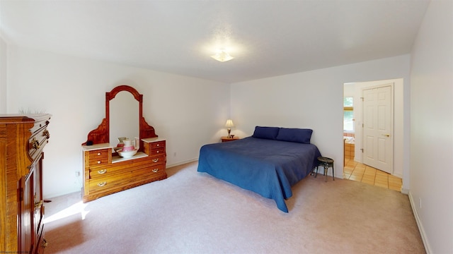 bedroom with light carpet and ensuite bath