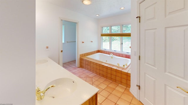 bathroom featuring tile patterned floors, tiled tub, and vanity