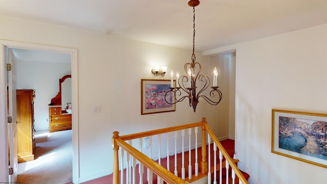 corridor with carpet flooring and a notable chandelier