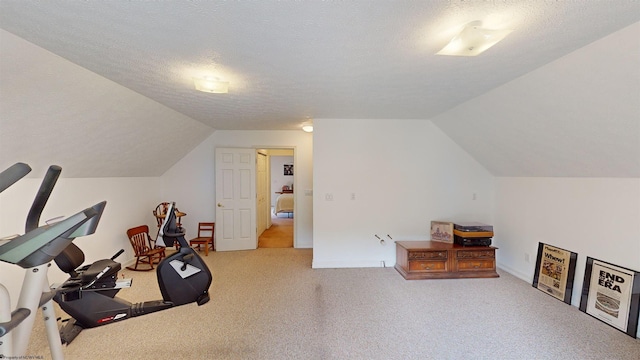 exercise area featuring a textured ceiling, light colored carpet, and lofted ceiling