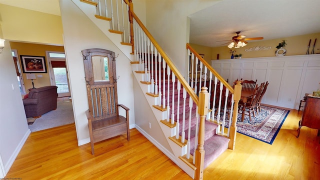 stairway with wood-type flooring and ceiling fan