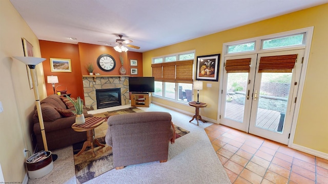 living room featuring a fireplace, ceiling fan, french doors, and light tile patterned floors