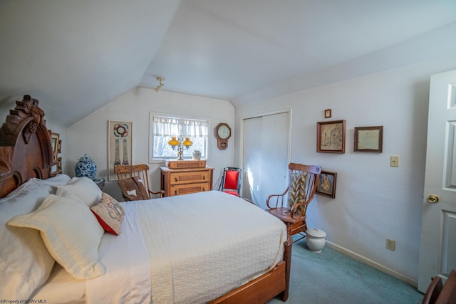 bedroom with vaulted ceiling, a closet, and carpet flooring