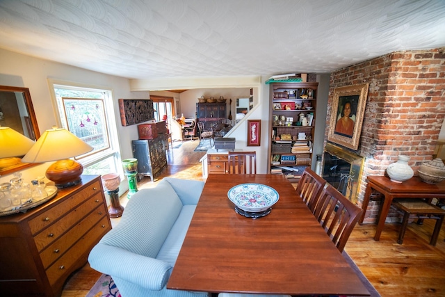 dining room with hardwood / wood-style floors and a fireplace