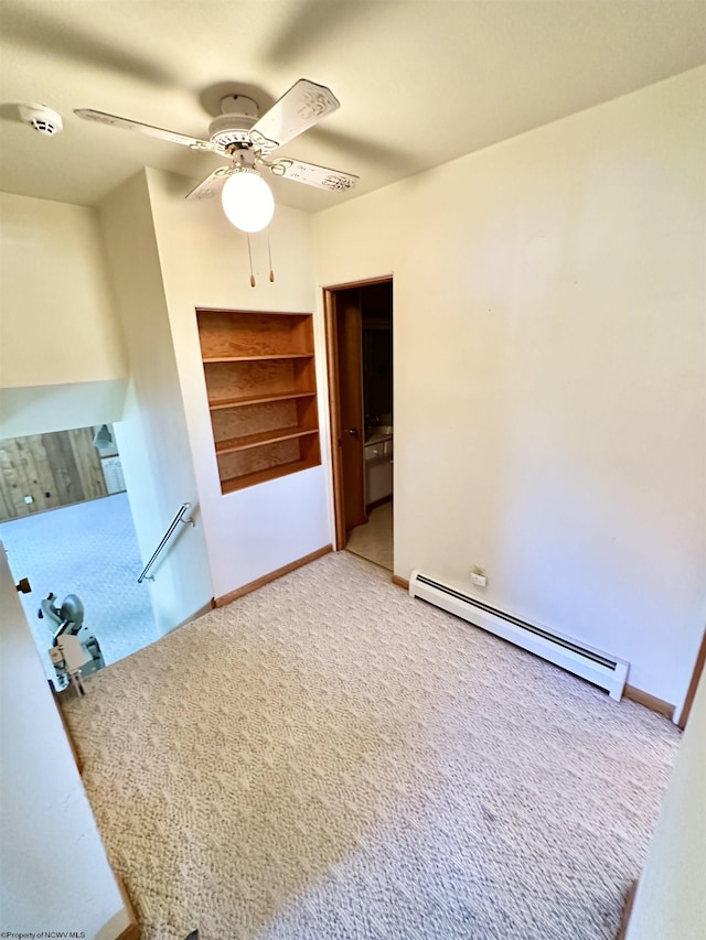 interior space with carpet flooring, ceiling fan, and a baseboard heating unit