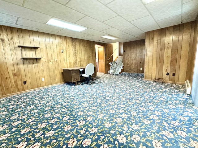 unfurnished office featuring carpet floors and wood walls