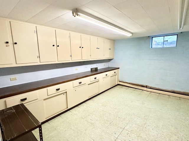 interior space with white cabinetry and baseboard heating