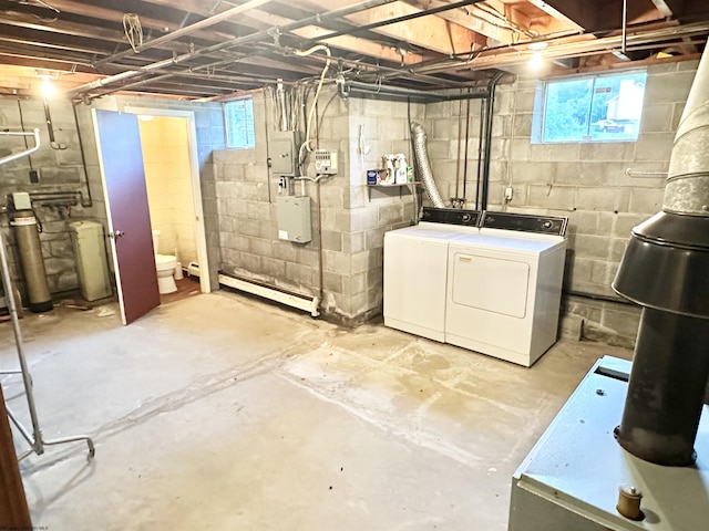 basement featuring washer and dryer, baseboard heating, and electric panel