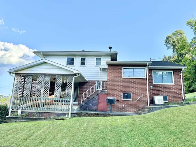 rear view of property featuring a lawn