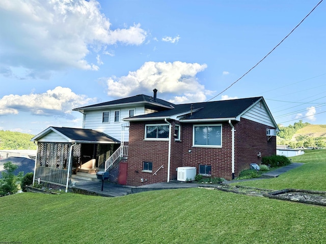 rear view of property with a lawn and a patio