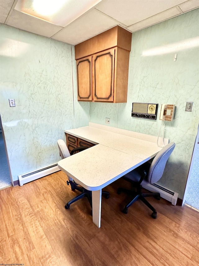 home office featuring a paneled ceiling, light wood-type flooring, and a baseboard radiator