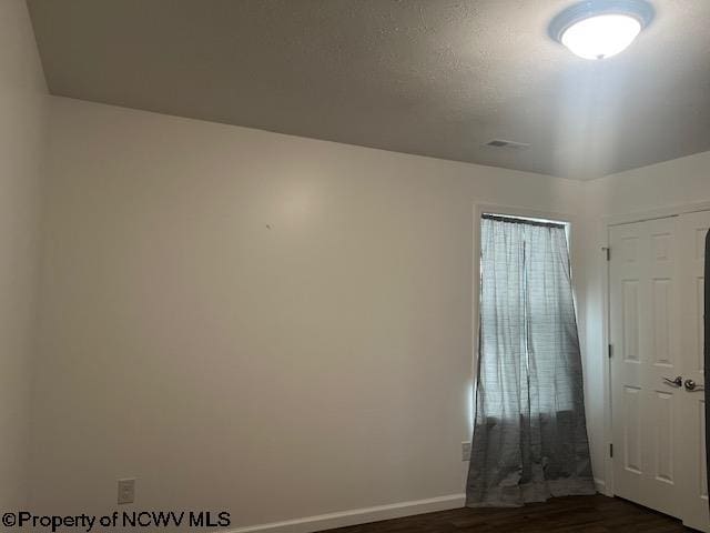 empty room featuring dark wood-type flooring