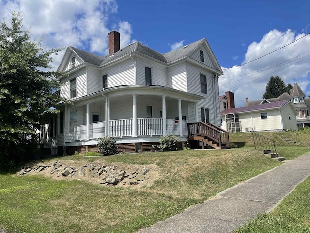 farmhouse inspired home featuring covered porch and a front lawn