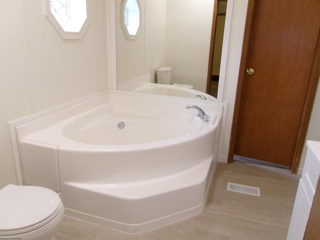 full bath with a garden tub, toilet, and visible vents