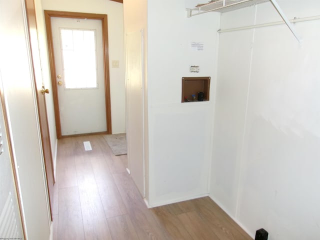 laundry area with light wood finished floors, laundry area, and washer hookup