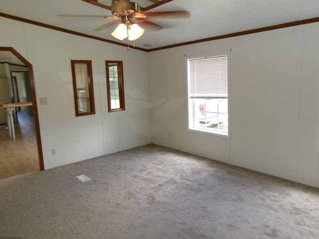 empty room featuring ceiling fan, lofted ceiling, carpet floors, and ornamental molding