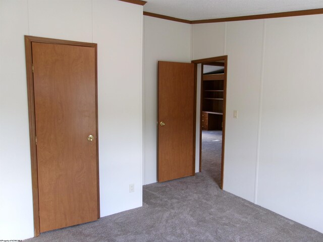 unfurnished bedroom featuring carpet floors and crown molding