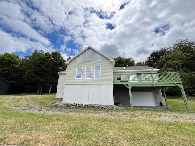 back of property with a deck, a garage, and a lawn