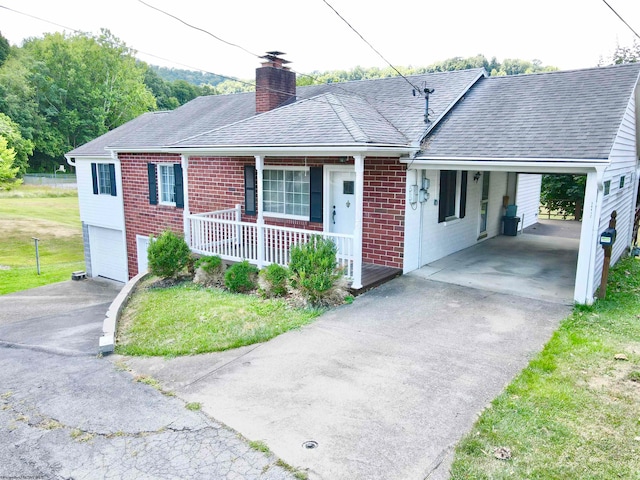 ranch-style house featuring a porch, a front lawn, and a carport