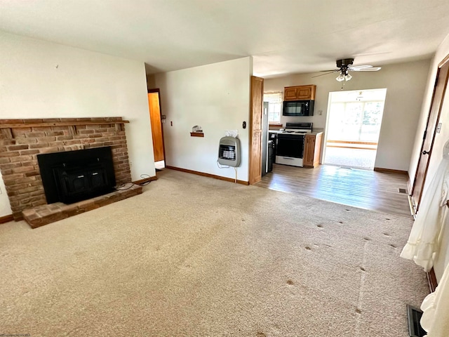 unfurnished living room with a fireplace, ceiling fan, and carpet flooring