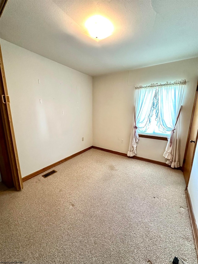 carpeted spare room featuring a textured ceiling