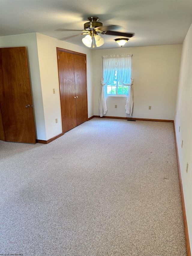 unfurnished bedroom with a closet, carpet flooring, and ceiling fan